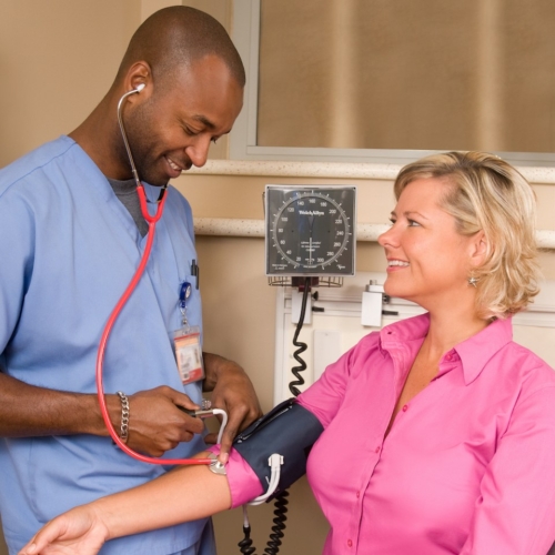 Male nurse taking patients blood pressure